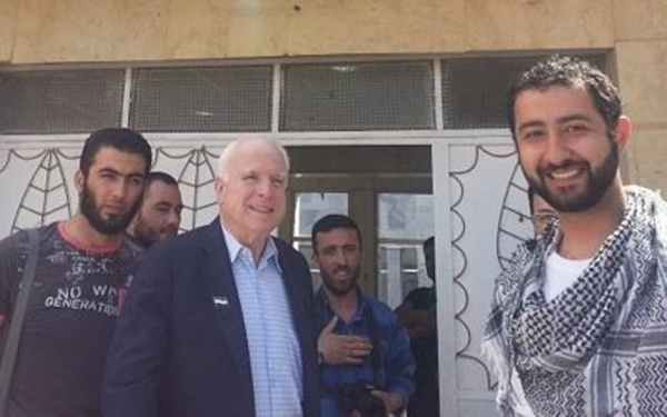 John McCain en Syrie. Au premier plan à droite, on reconnaît le directeur de la Syrian Emergency Task Force. Dans l’embrasure de la porte, au centre, Mohammad Nour.