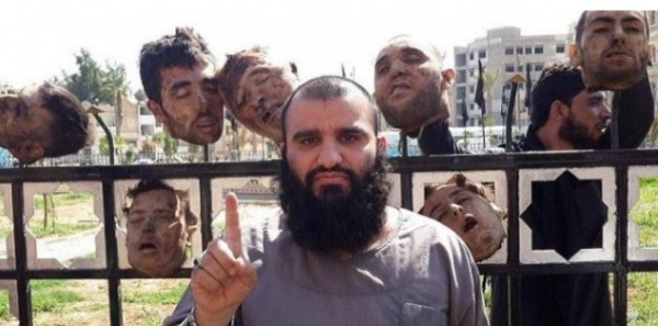 Un islamo-fasciste posant devant les têtes de chrétiens décapités en Irak et exhibées sur 600 m dans une avenue de Mossoul.