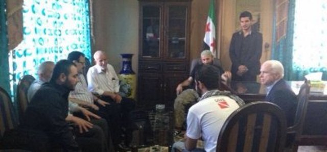 John McCain et l’état-major de l’Armée syrienne libre. Au premier plan à gauche, Ibrahim al-Badri, avec lequel le sénateur est en train de discuter. Juste après, le brigadier général Salim Idriss (avec des lunettes).